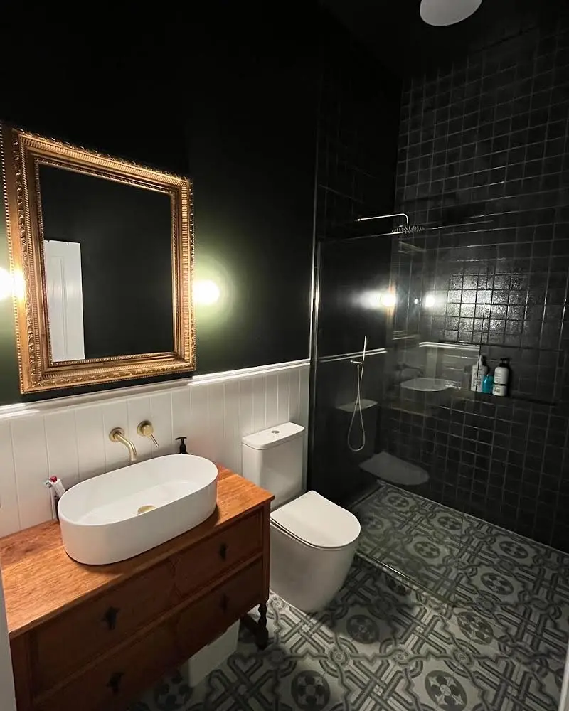 Dark-tile bathroom with timber vanity
